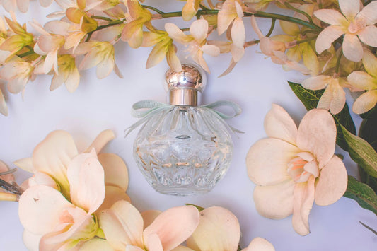 A perfume bottle surrounded by flowers