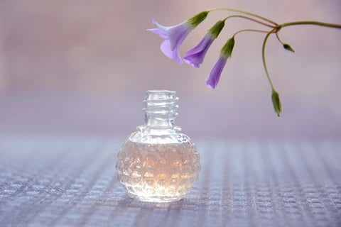 A woman spraying perfume on her neck