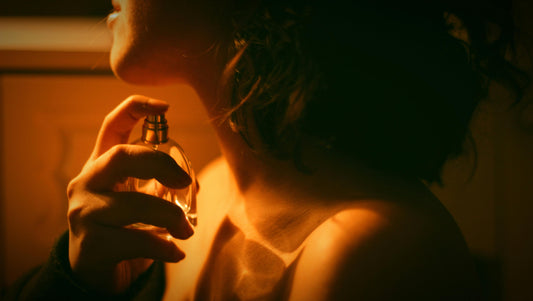 A woman spraying perfume on her neck